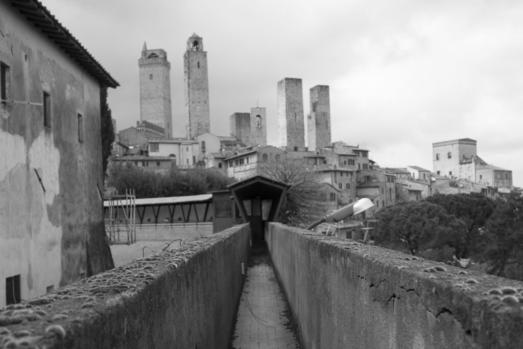 Veduta panoramica in bianco e nero della corte interna con il pozzo e il loggiato, durante le prime fasi di trasformazione del complesso Excelle