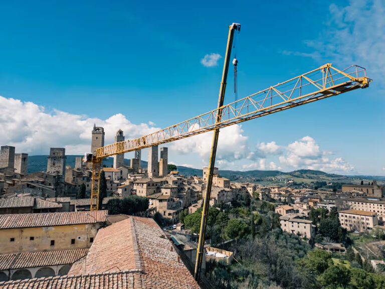 Veduta panoramica di San Gimignano con le sue torri medievali e la campagna toscana dal cantiere di restauro di Excelle