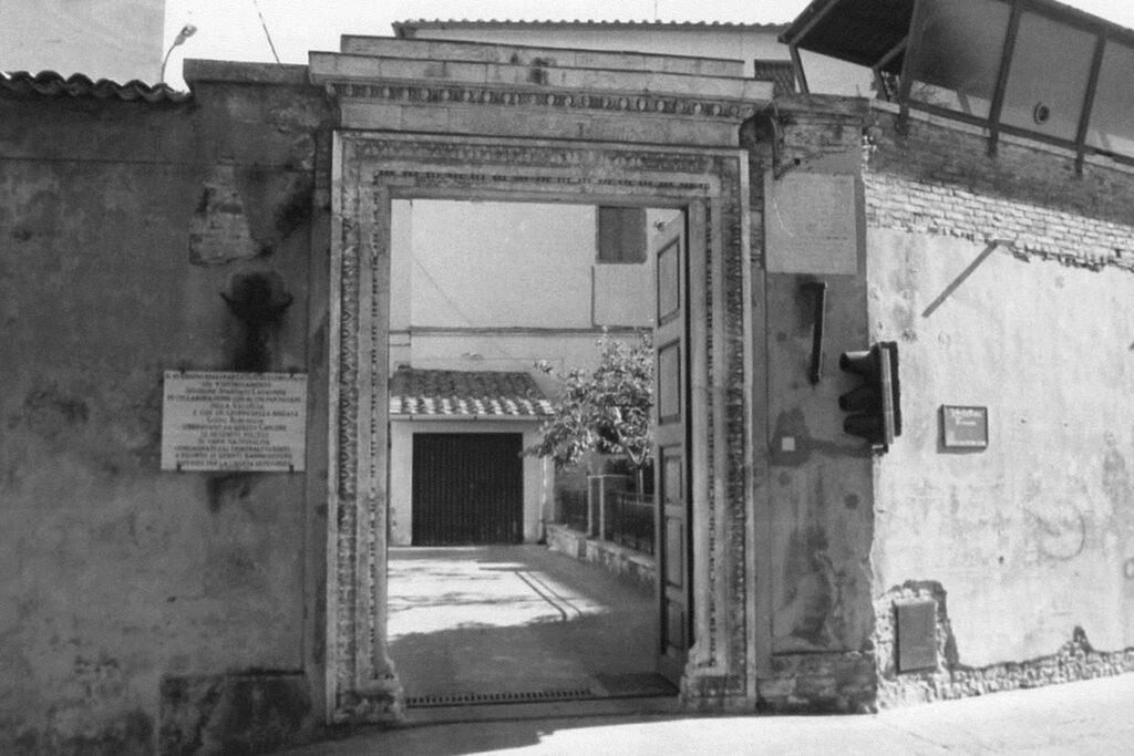 Fotografia d'epoca del portale in pietra decorata che segna l'ingresso principale al complesso storico di San Domenico a San Gimignano